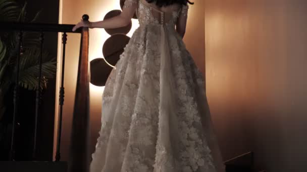 レストランの階段を歩く白いエレガントなドレスを着た女性の背面図 — ストック動画