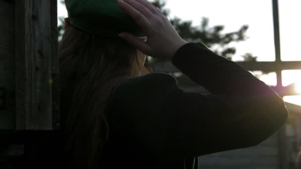 田舎で緑のベレーを固定する女性のバックビュー — ストック動画