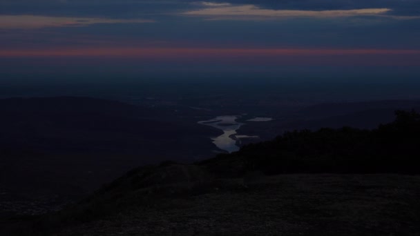 Τεράστιος ποταμός αντανακλά πορτοκαλί ηλιακό φως ανάμεσα στους λόφους — Αρχείο Βίντεο