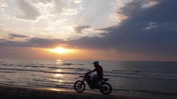Ciclista silueta paseos a lo largo de la playa de arena en el océano sin fin — Vídeo de stock