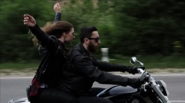 Erkek ile yükseltilmiş eller sürmek motosiklet ile Bayan, tepeler karşı geçmiş yol engelleri