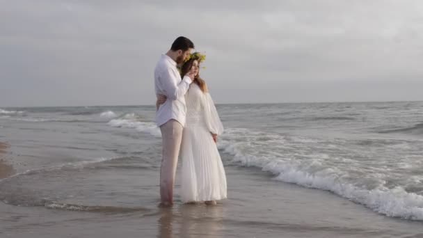 Συναρπαστικό Ρομαντικό Ζευγάρι Στέκεται Στην Αμμώδη Παραλία Αφρούς Θαλάσσια Κύματα — Αρχείο Βίντεο