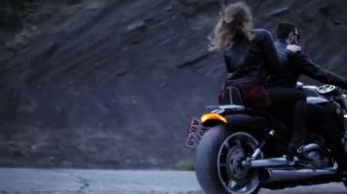 siyah Biker ceketler heyecan verici çift tepeler çevrili gri yol boyunca modern motosiklet sürmek