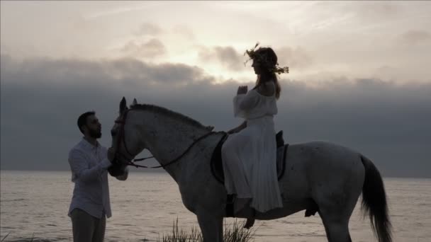 Giovane Donna Silhouette Siede Sella Cavallo Uomo Barbuto Tiene Cavezza — Video Stock