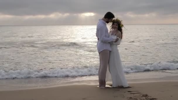 Ρομαντικό Ζευγάρι Στέκεται Στην Αμμώδη Παραλία Ενάντια Στα Κυλιμένα Αφρώδη — Αρχείο Βίντεο