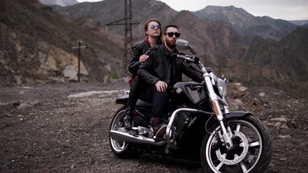 Stijlvolle Paar Zwarte Dressing Zonnebril Zit Motorfiets Tegen Bruine Rotsachtige — Stockvideo
