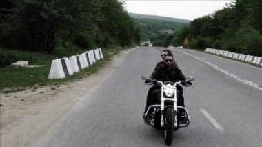 şık çift beyaz taş bariyerleri ile dağ yolu boyunca siyah modern motosiklet sürmek