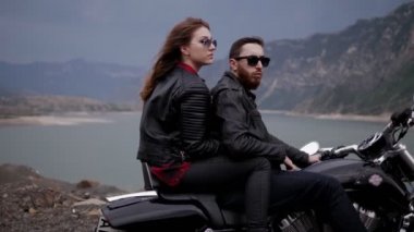siyah soyunma romantik çift sakin göl ve resimsel tepeler karşı modern motosiklet oturur