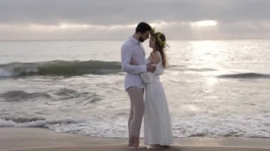 sonsuz denize karşı kumlu plajda ayakta iken yalınayak romantik çift sarılıyor