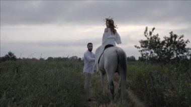 beyaz elbise gökyüzü gri at kadın yürüyüş yakınında yeşil çayır yol