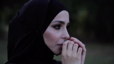 muhteşem makyaj ile Arap Bayan karanlık hijab ve dua giyer