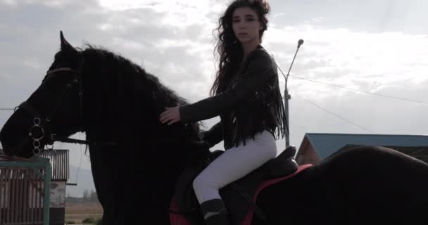 Ervaren meisje Rider met lange haren fixes krullend hengst Mane — Stockvideo