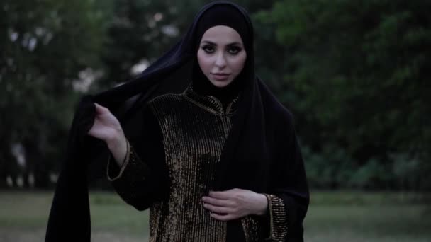 Araba donna in abaya cammina per macchina fotografica e nasconde il viso — Video Stock