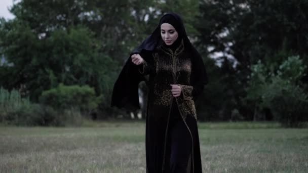 Arabische dame in Abaya jurk houdt hijab hem tegen wind — Stockvideo