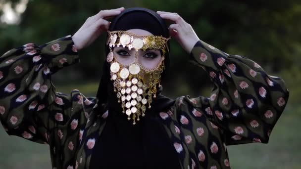 Леди носит традиционную арабскую одежду и золотую вуаль для лица — стоковое видео
