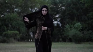 uzun siyah abaya elbise li arap kadın park boyunca yürüyor