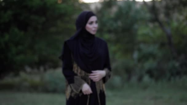 Hermosa joven dama en árabe abaya vestido hijab en parque — Vídeos de Stock