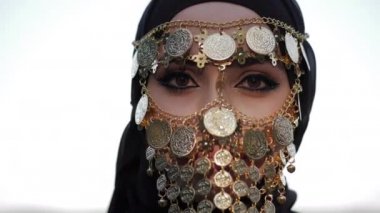 hijab ve altın sikke yüz peçe parlak makyaj ile kadın