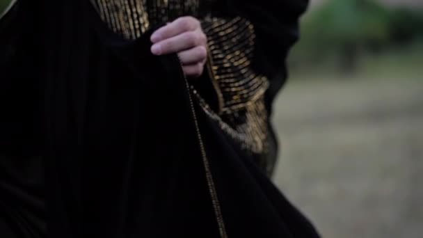 Arabische Frauenhände halten traditionelles langes schwarzes Kleid — Stockvideo