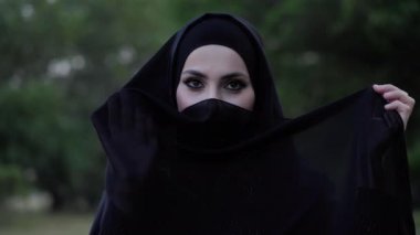 ciddi kadın siyah başörtüsü giyer ve elinde kenar tutar