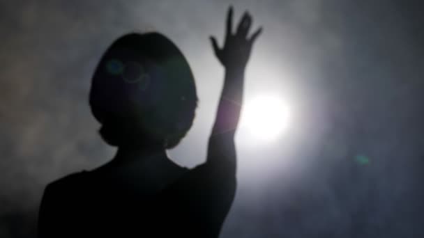 Silhouet van meisje het verhogen van de hand tegen lichte Slow Motion — Stockvideo