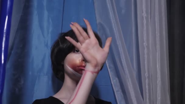 Dziewczyna z artystycznym makijażu dotyka przezroczystego tworzywa sztucznego ściany — Wideo stockowe