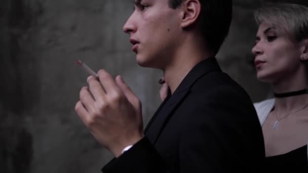 Hombre guapo fuma cigarrillo cerca de dama seria primer plano lento — Vídeo de stock