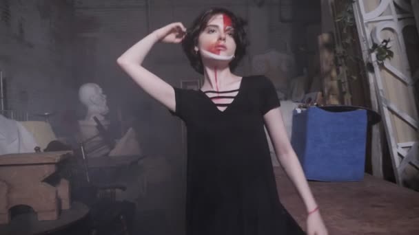 Όμορφη νεαρή ηθοποιός εκτελεί μεταξύ παλαιών τραπεζιών στο στούντιο — Αρχείο Βίντεο