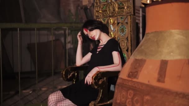 Menina entediada com maquiagem elegante senta-se no trono câmera lenta — Vídeo de Stock