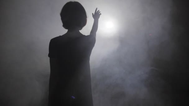 Movimiento de niña silueta saludo luz en el humo grueso — Vídeo de stock
