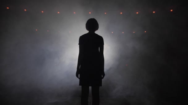 Girl Silhouette står mot Bright Spotlight på scenen — Stockvideo