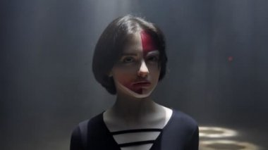 yüzünde boya ile güzel kız parlak ışık ışın bakar