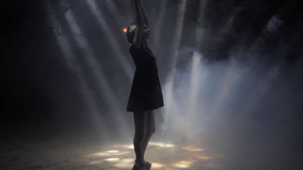 Jolie fille avec un maquillage élégant lève les mains aux rayons de lumière — Video