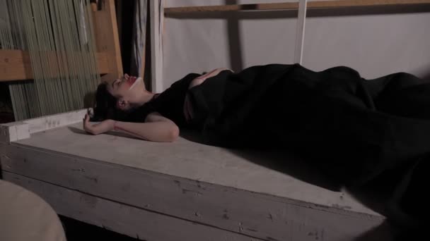 Lány színes arca alszik az ágyban, fekete takaró — Stock videók