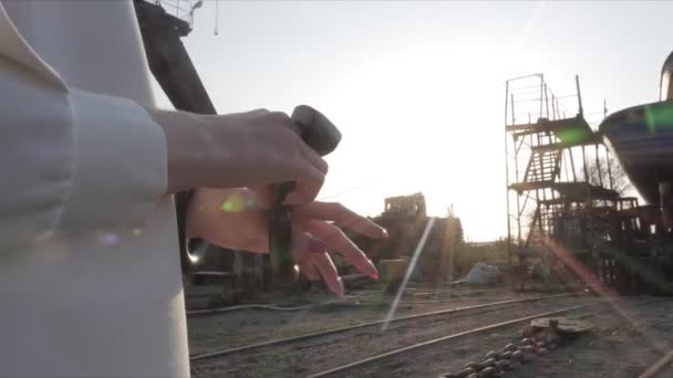 Chica pone en pulsera en los rayos del sol estructuras penetrantes — Vídeos de Stock