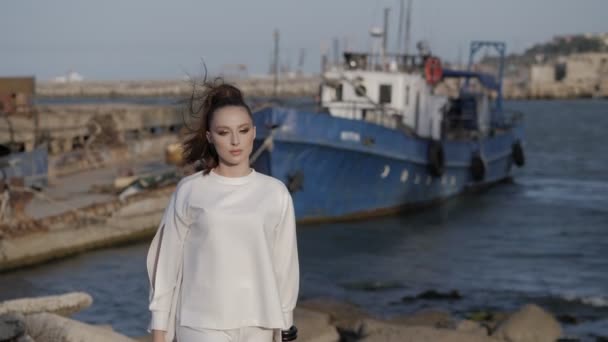 Dame marche le long du vieux port de mer contre bateau à moteur amarré — Video