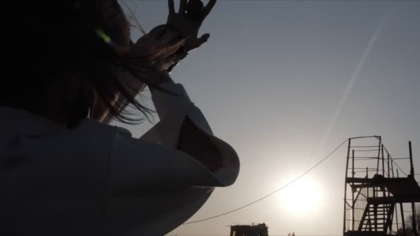 Mujer silueta trazos mano ocultándose de puesta de sol — Vídeo de stock