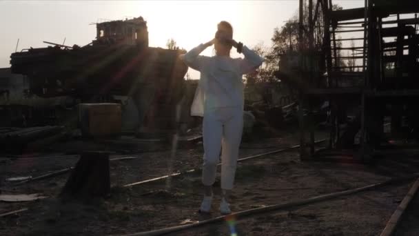 Dívka se dívá na port pomocí dalekohledu proti večernímu slunci — Stock video