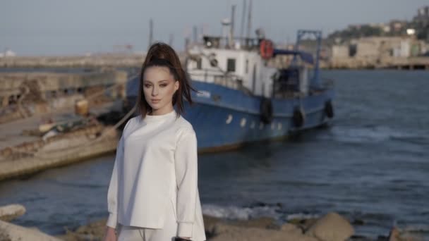 Jolie dame pose contre bateau à moteur par poste à quai et mer calme — Video