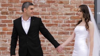Dar gelinlikli, duvak takmış ince gelin nişanlısını takip ediyor.