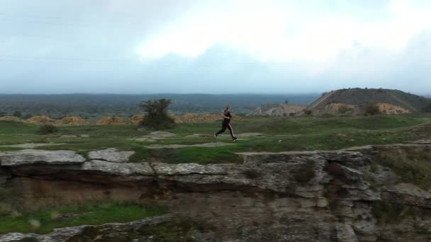 Jong sportief vrouw geniet van hardlopen op Tarki canyon heuvelrug — Stockvideo