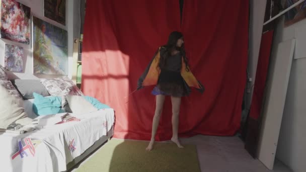 Barfüßige Frau tanzt in sonnigem Kunstatelier neben rotem Stoff — Stockvideo