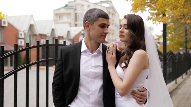 Noivo elegante no terno preto abraça noiva com cabelo encaracolado longo — Vídeo de Stock