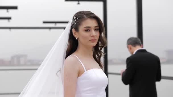 Sposa in abito da sposa con lungo velo soffice contro fidanzato — Video Stock