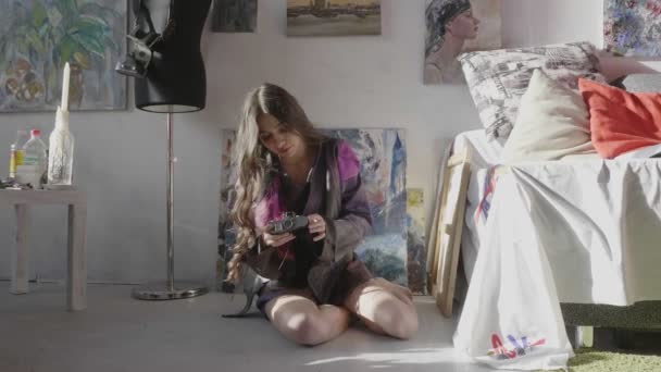 Леді мелодії цифрової камери, щоб сфотографуватися, сидячи на підлозі — стокове відео