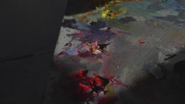 Peinture de couleur vive répartie sur la palette dans le studio d'art gros plan — Video