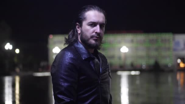 Man in leather jacket stands on square at rain in evening — Stock Video