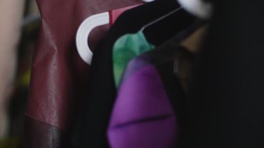 Kadın kostüm odasındaki askılardan şık kostümler seçiyor.