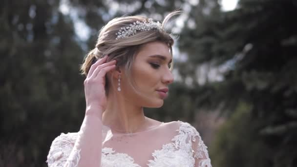 Novia en vestido de novia con cordones y tiara en el parque soleado — Vídeos de Stock