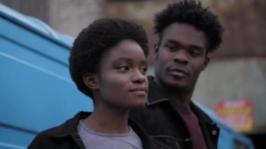 Afro-Amerikalı kadın sokakta siyahi bir adamın yanında duruyor.